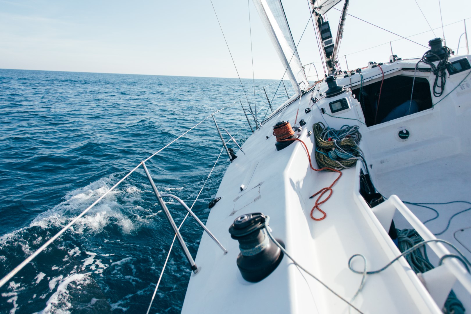 deck professional sailboat racing yacht during competition sunny windy summer day moving fast through waves water with spinnaker up Buyuk